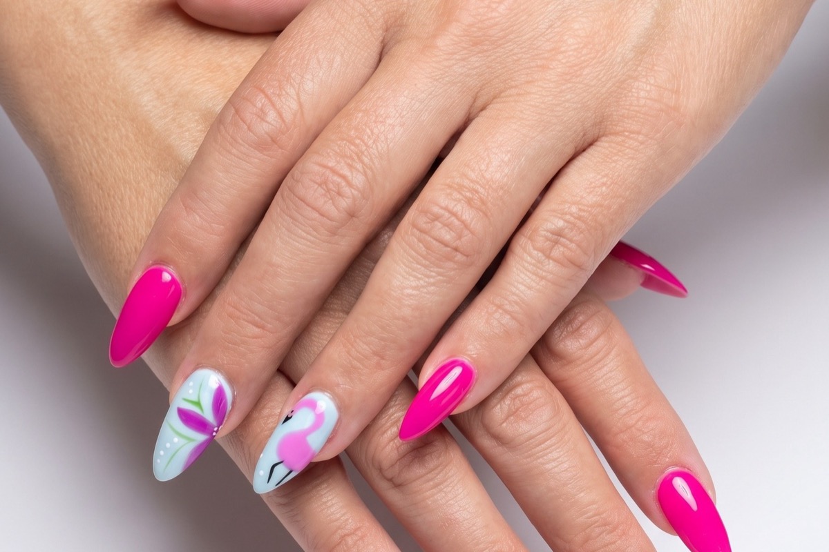 Hot pink almond nails with pale blue accent nails hand-painted with a flamingo and a hibiscus flower